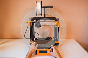 Technological hi-teg tool for making new things. A black and red 3D printer at work. The object is created by laying down