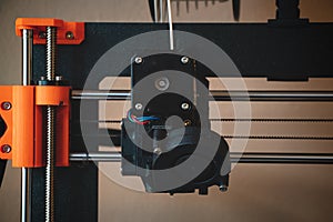 Technological hi-teg tool for making new things. A black and red 3D printer at work. The object is created by laying down