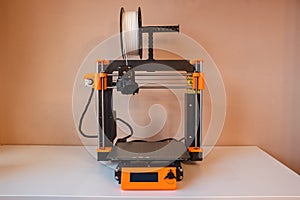 Technological hi-teg tool for making new things. A black and red 3D printer at work. The object is created by laying down photo