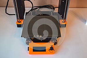 Technological hi-teg tool for making new things. A black and red 3D printer at work. The object is created by laying down