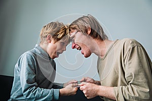 Technology addiction- father taking mobile phone from angry child