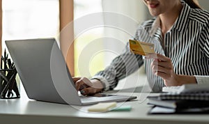 technology, asian woman online shopping concept - happy smiling woman with laptop computer and credit card at home