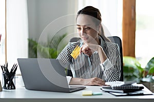 technology, asian woman online shopping concept - happy smiling woman with laptop computer and credit card at home