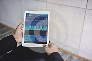 Technology in Finance and Business Marketing Concept. Graphs and Charts show on Touch Pad`s Screen. Modern Businessman seeing