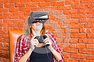 Technology, gaming, entertainment and people concept - young woman with virtual reality headset, controller gamepad