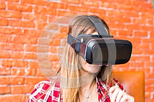 Technology, gaming, entertainment and people concept - young woman with virtual reality headset, controller gamepad