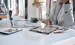 Technology has always been an asset in the business world. an unrecognizable businesswoman using a digital tablet while