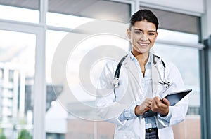 Technology helps me do a better job. Portrait of a young female doctor using a digital tablet in a hospital.