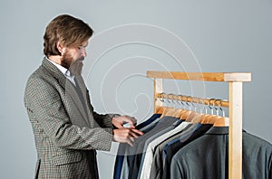 Technology always helps at work. tailor in his workshop. Handsome bearded fashion man in classical costume suit. Man in