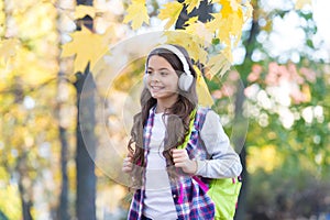 Technology for language learning. Happy child wear headphones autumn outdoors. Foreign language courses. English school