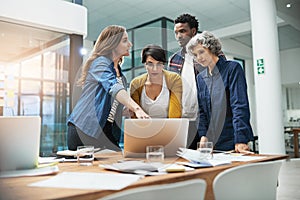 Technology makes their meetings more efficient. Shot of a team of creative businesspeople brainstorming around a laptop