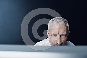 Technology, man working on his computer and against a studio background. Connectivity or social networking, research or