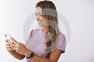 Technology mobile user concept. Attractive happy tender girl looking smartphone display holding phone smiling gadget photo