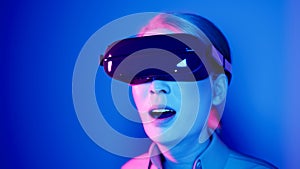 technology, online game, entertainment, virtual world in 3D simulation. millennial woman in vr glasses plays in the neon