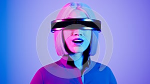 technology, online game, entertainment, virtual world in 3D simulation. millennial woman in vr glasses plays in the neon
