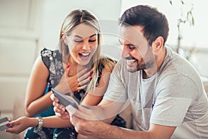 Smiling happy couple couple with tablet pc computer and credit card at home