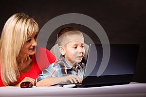 Technology and parenting - boy and mother with laptop