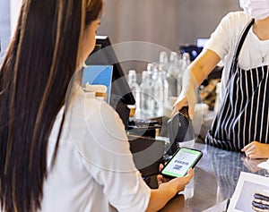 Technology and Payment concept. Young woman using wireless or contactless payment by smart phone