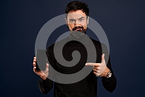 Technology, people and communication concept.Portrait of upset and disappointed,gloomy bearded caucasian man pointing finger at