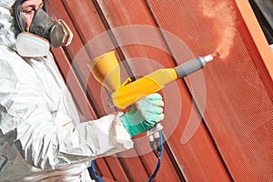 Polymer coating of metal detail with powder spraying gun photo