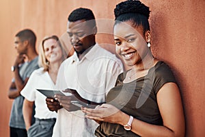 Technology runs this generation. Cropped portrait of an attractive young businesswoman standing with her colleagues