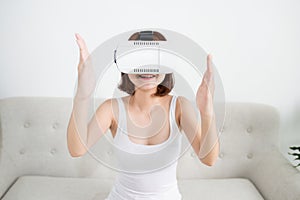 Technology, virtual reality, entertainment happy young asian woman with virtual reality headset at home and touching something in