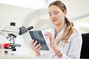 Technology is a vital tool for every researcher. Cropped shot of a young female scientist recording her findings on a