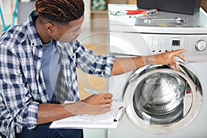 tecnician fixing washing machine at clients home photo