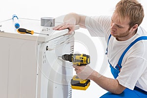 Tecnician fixing a washing machine photo