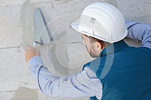 Tecnician plastering exterior wall photo