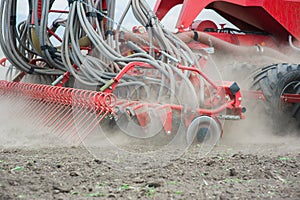 Tedder rake work in field with dust