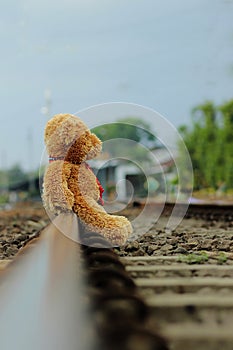 Teddy bear is alone on the train tracks