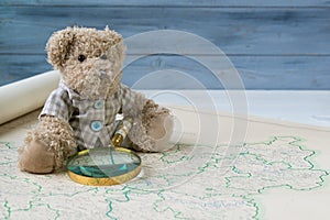 Teddy bear with antique magnifying glass see the old map of Germany