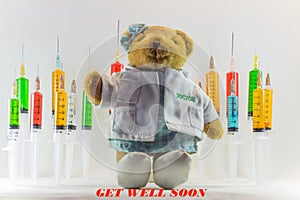 Teddy bear as a woman doctor with plastic medical syringes containing multicolor solutions and white background.`Medical concept`