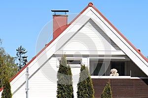 A teddy bear in a balcony of a detached house