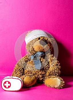 Teddy bear with bandage and first aid for mishap concept