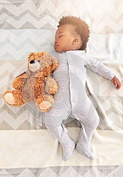 Teddy bear, bed and baby sleeping in home with lens flare for rest, nap time and dreaming in nursery. Childcare, newborn