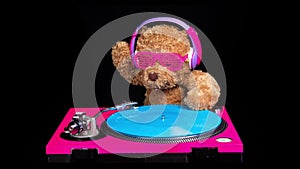 Teddy bear djing on turntables with headphones