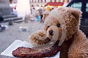 Teddy bear Dranik eating cake on christmas market