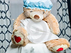 A teddy bear full body portrait  wearing a shower cap and a towel