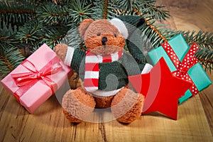 Teddy bear with gifts for Christmas, spruce branches and red star