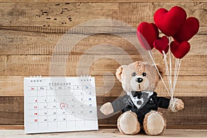 Teddy bear holding heart-shaped balloon
