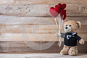 Teddy bear holding heart-shaped balloon