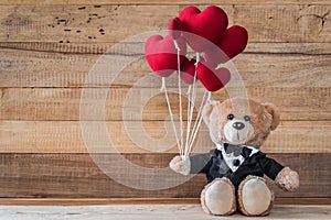 Teddy bear holding heart-shaped balloon