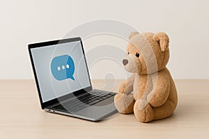 Teddy bear looking at laptop.