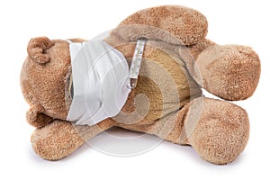 The teddy bear lying ill with a coronavirus in a medical mask