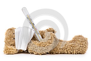 The teddy bear lying ill with a coronavirus in a medical mask