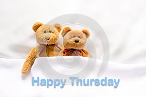 Teddy Bear lying in the white bed with message Happy Thursday photo