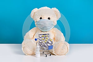 Teddy bear in medical mask and shopping cart with pills. Concept of illness, virus protection and buying medicine