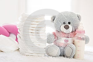 Teddy bear with nappies and bottle with milk photo